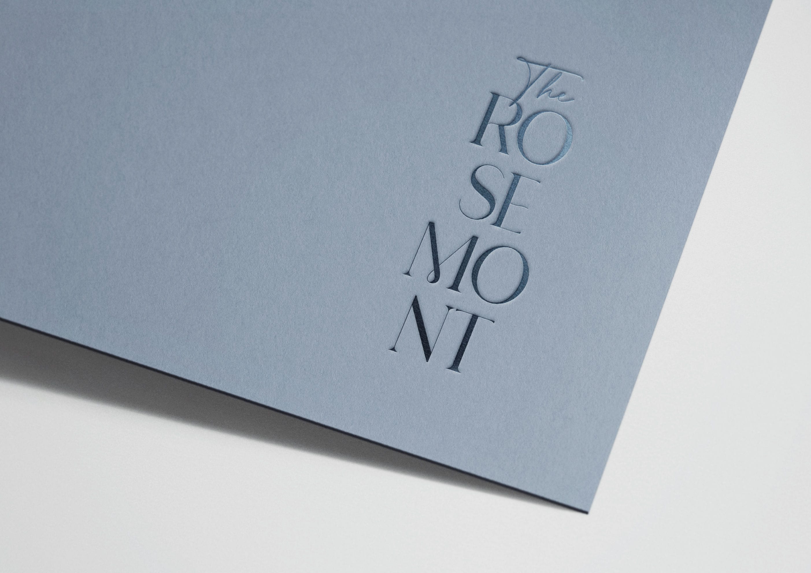 The Rosemont brand identity close-up showing embossed logo on blue-grey stock &mdash; branding by Ademchic