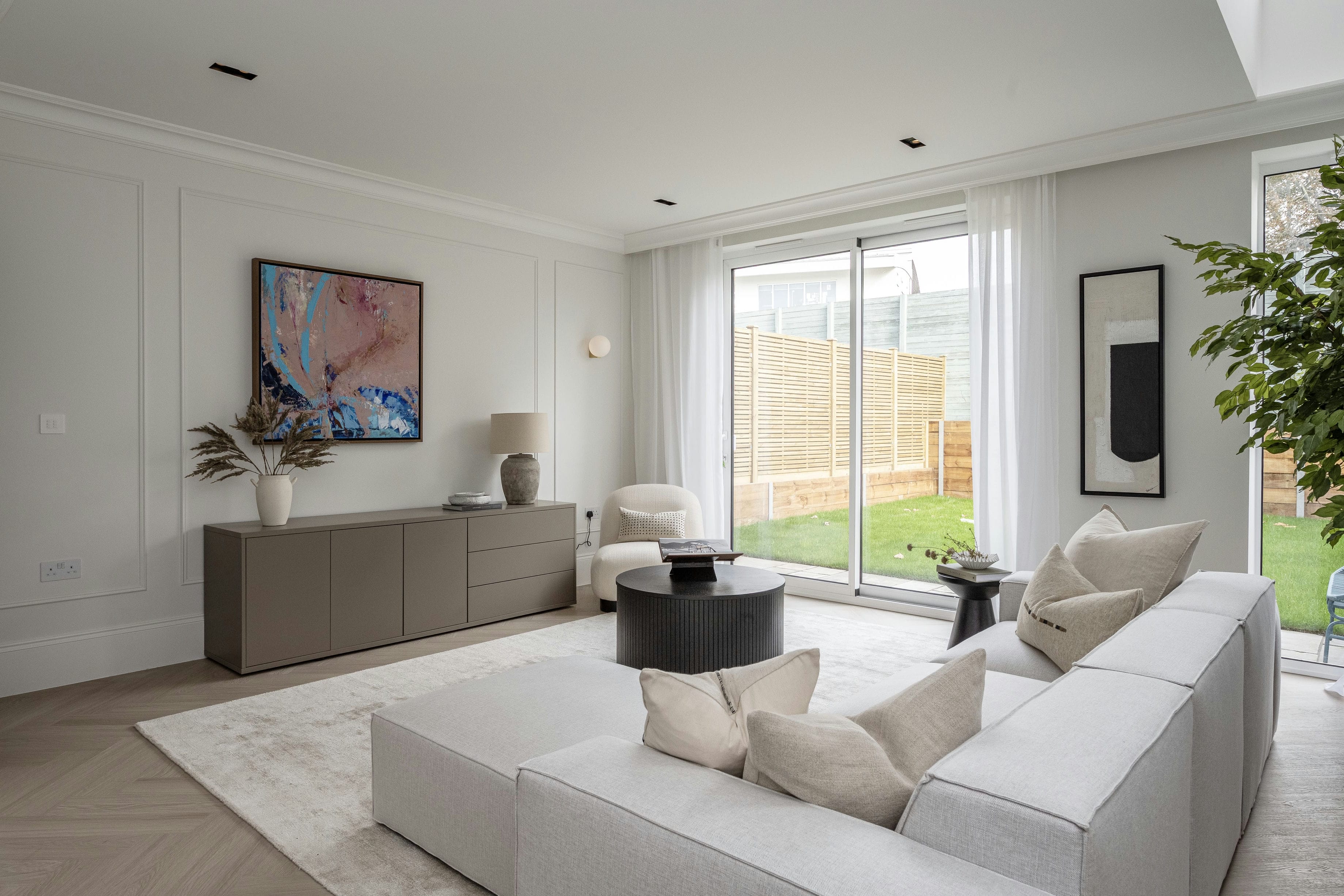 The Rosemont house living room with panelled walls, garden view and contemporary furniture &mdash; interior design by Ademchic