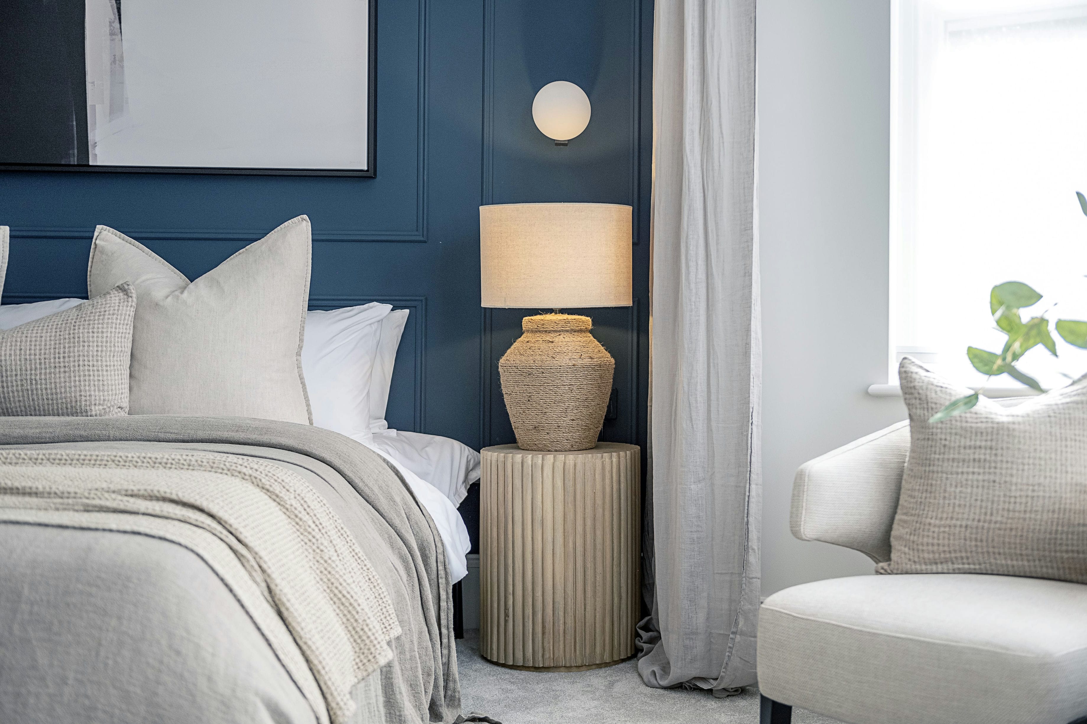 The Rosemont bedroom detail with blue panelled wall, bedside table and wall light &mdash; designed by Ademchic